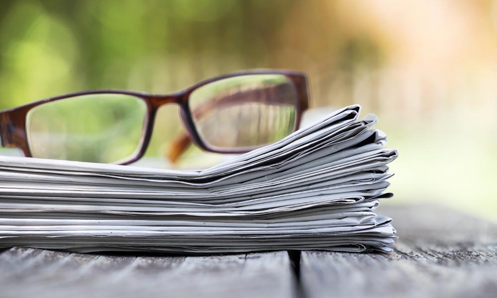 photo of glasses on newspapers